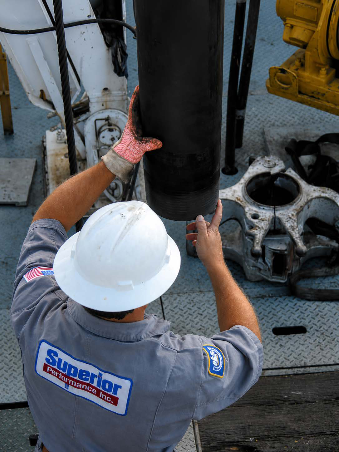 Field specialist guiding a connection at the rig floor